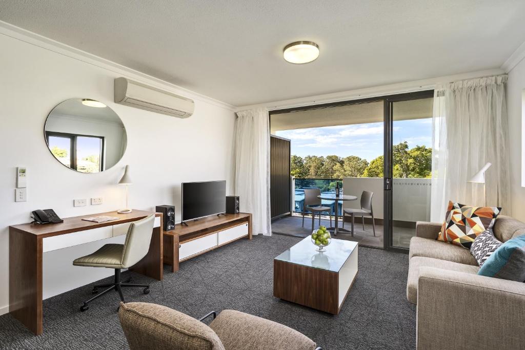 a living room filled with furniture and a tv at Quest Kelvin Grove in Brisbane