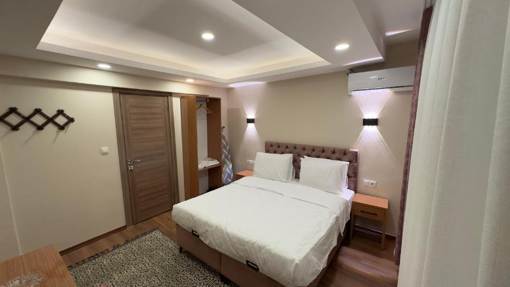 a bedroom with a white bed and two lamps at Golden Tulip Suite Apart in Istanbul