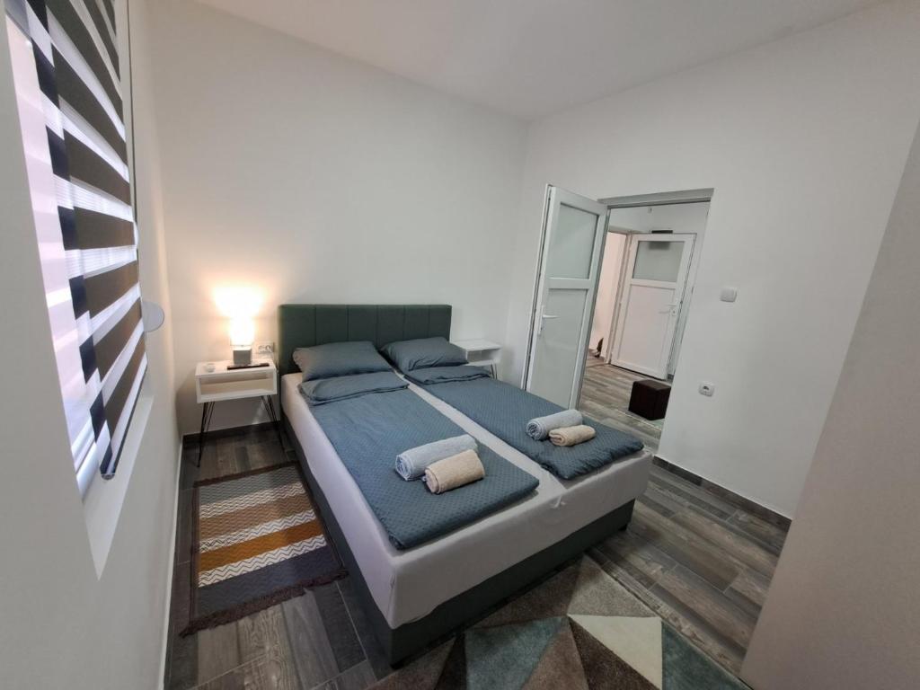 una camera da letto con un letto con lenzuola blu e uno specchio di Apartman Arsić Zajecar a Zaječar
