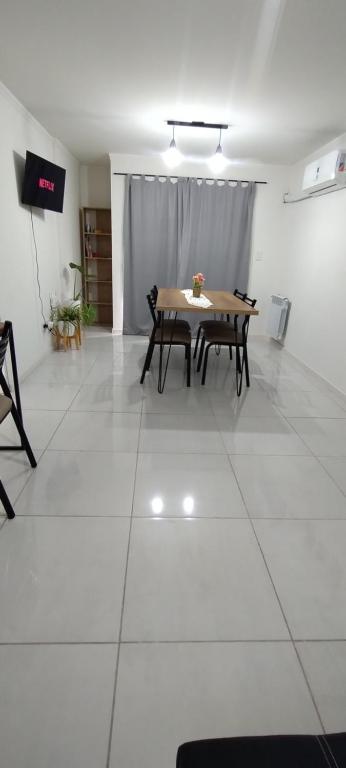 d'une salle à manger avec une table sur du carrelage blanc. dans l'établissement Departamento amoblado alquiler temporario, à Río Cuarto