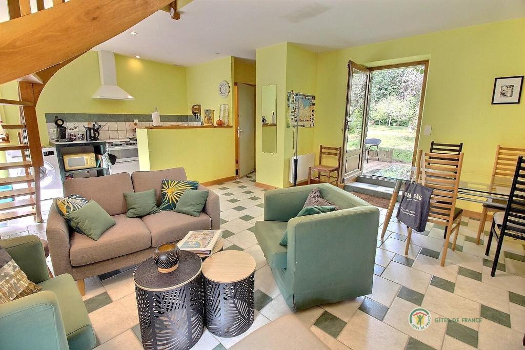 a living room with a couch and chairs and a table at Tournesol in Saint-Gildas