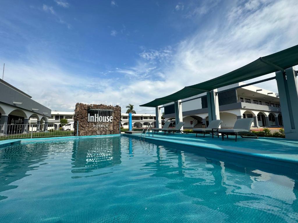uma piscina com cadeiras e um hotel em InHouse Obregón em Ciudad Obregón