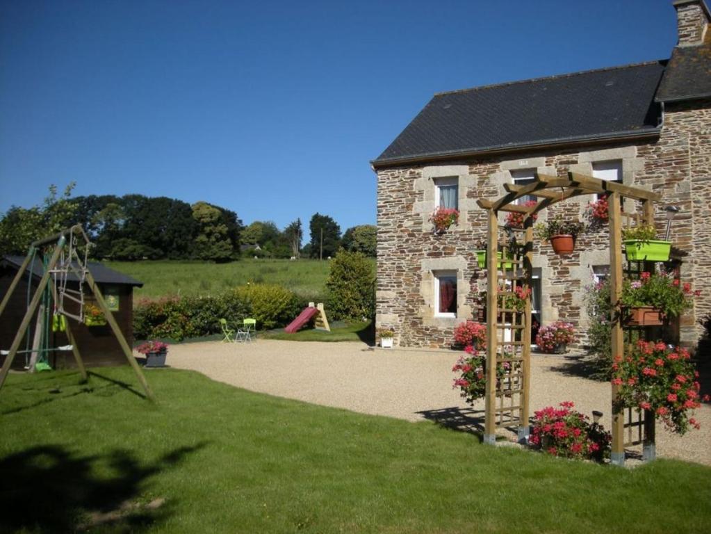 een stenen gebouw met een boog en een speeltuin bij Les cerisiers 