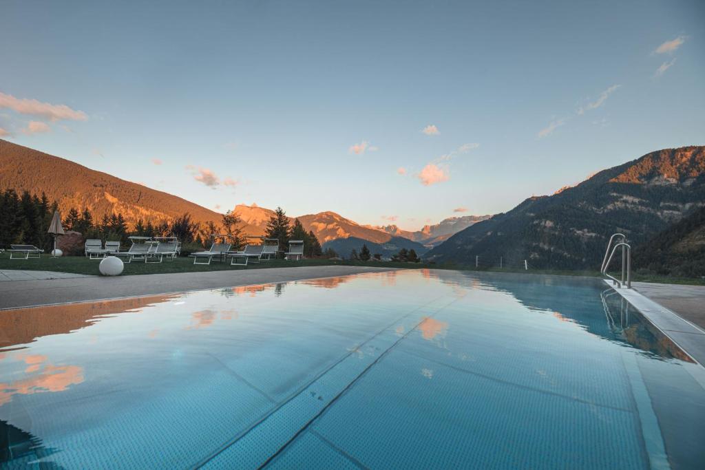 una gran piscina con montañas en el fondo en Villa Scherlin, en Ortisei