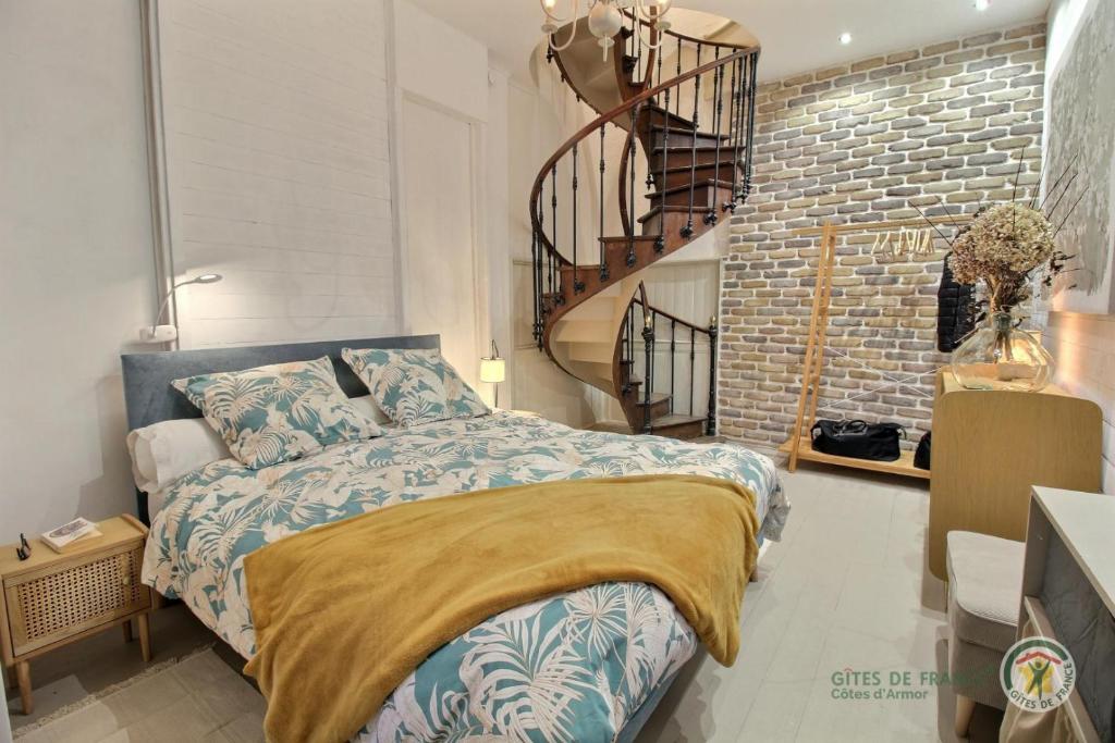 a bedroom with a bed and a brick wall at La terrasse du champ clos in Dinan