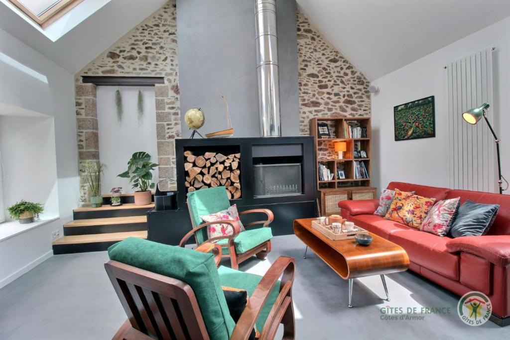 sala de estar con sofá rojo y sillas en La ritournelle, en Pleslin-Trigavou