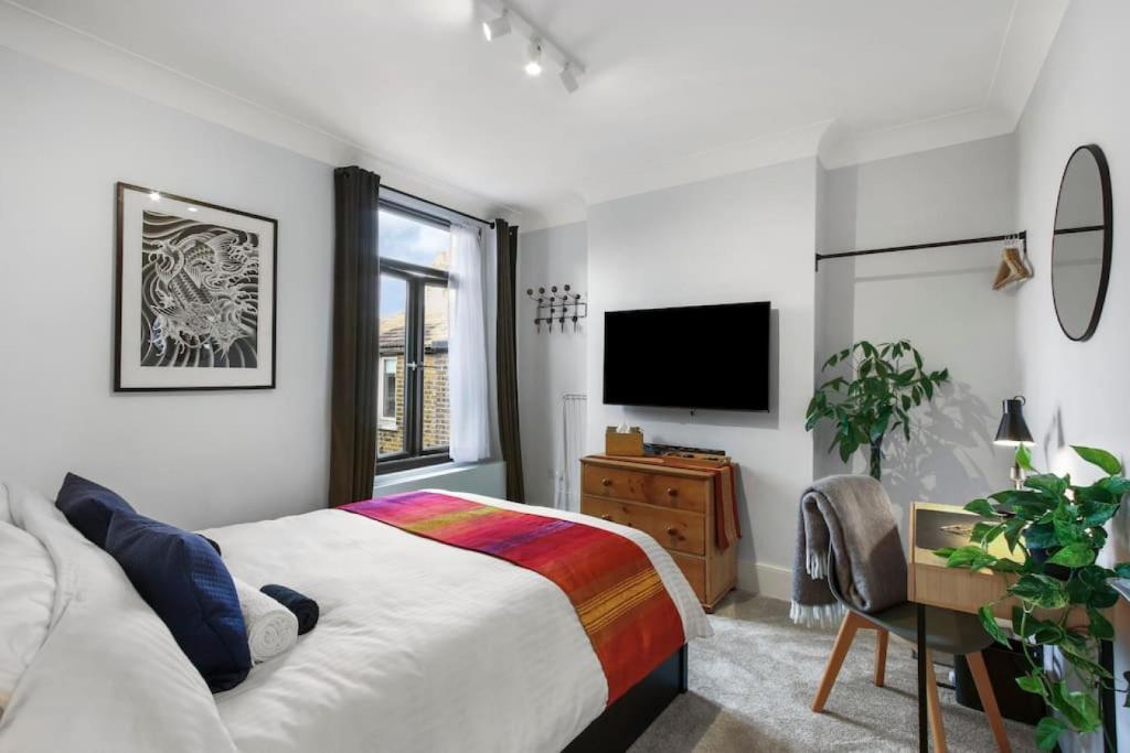 a bedroom with a bed and a flat screen tv at Modern Double bedroom in city apartment room 2 in London
