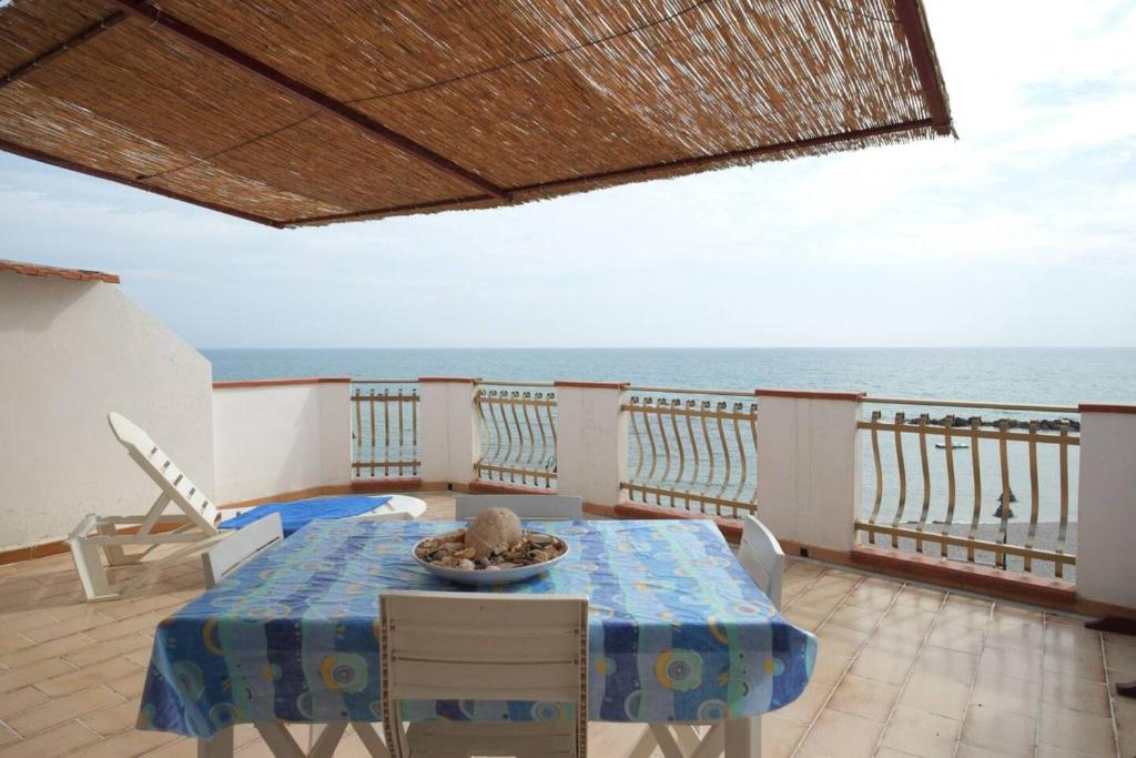 una mesa y sillas en un balcón con vistas al océano en Appartamento B - Le Terrazze, en Ribera