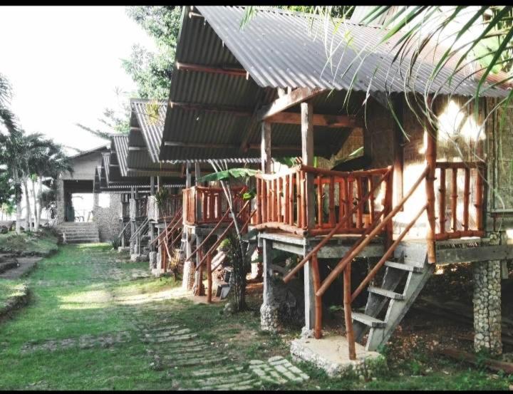a wooden house with a staircase leading to it at Palaboy Skatecamp Beach Resort 