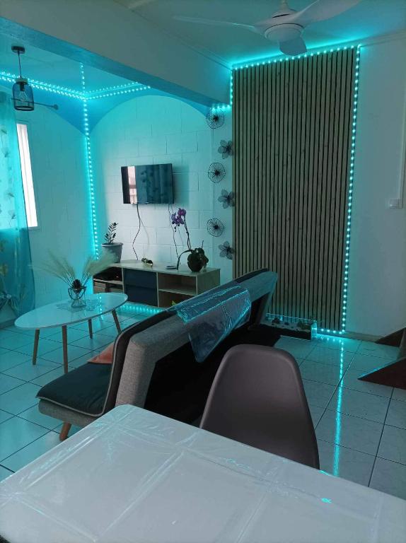 a room with a table and chairs and blue lights at Villa Imelda à saint André la réunion in Le Patelin