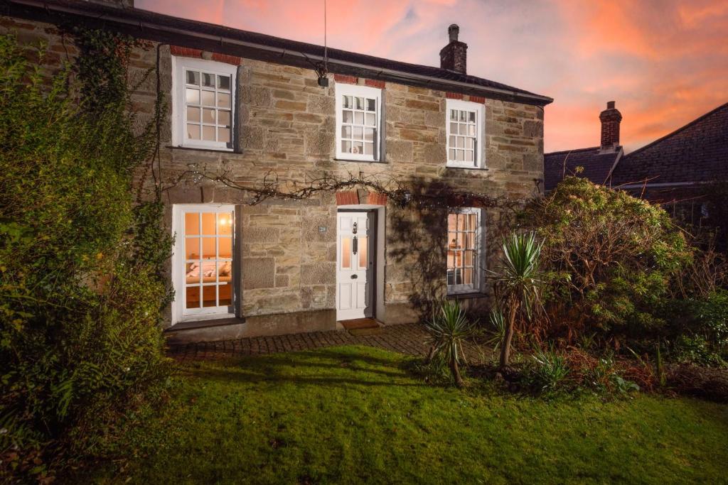 an old stone house with a white door at Roseneath in St. Agnes