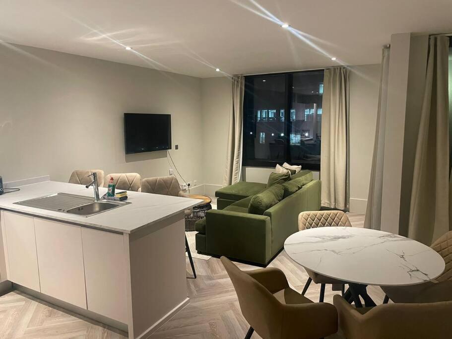 a kitchen and living room with a couch and a table at Luxurious 1 Bed - CITY VIEWS in Liverpool