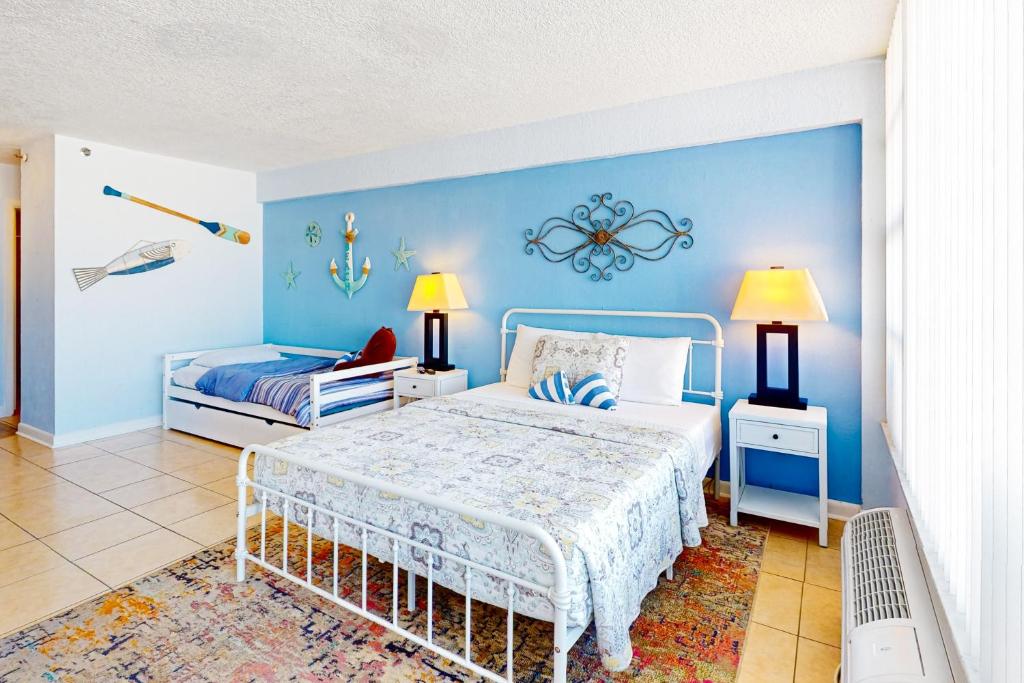 a bedroom with a bed and a blue wall at Daytona Dreamin' Unit 320 in Daytona Beach
