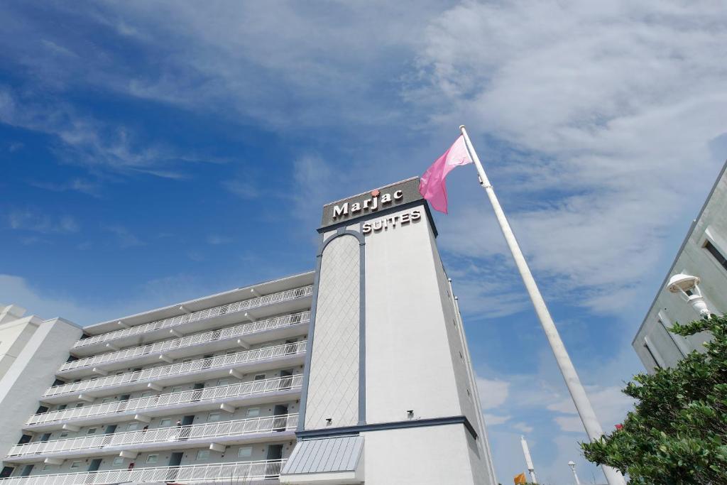 un hotel con bandera en la parte superior de un edificio en Marjac Suites Virginia Beach Oceanfront, en Virginia Beach