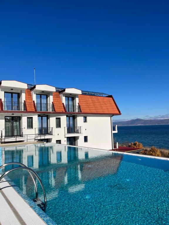 a swimming pool in front of a building with the ocean at Dishli Hotel & Spa in Struga