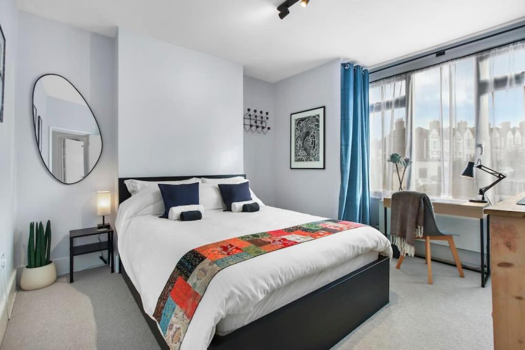 een slaapkamer met een bed, een bureau en een raam bij Modern Double bedroom in city apartment room 1 in Londen
