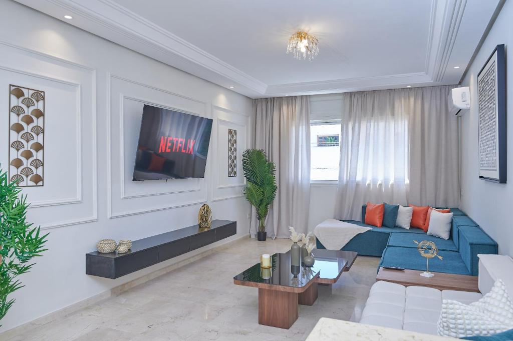 a living room with a blue couch and a tv at YourPlace Rabat Agdal 1 - Cozy Residence in Rabat