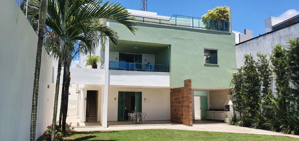 een huis met een balkon met een palmboom bij Casa Vista Pontal in Ilhéus