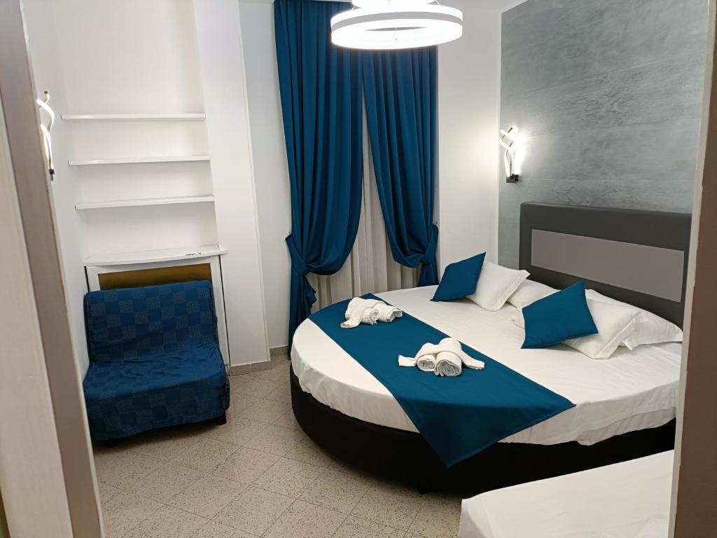 1 dormitorio con 1 cama y 1 silla azul en House 4 Mori, en Roma