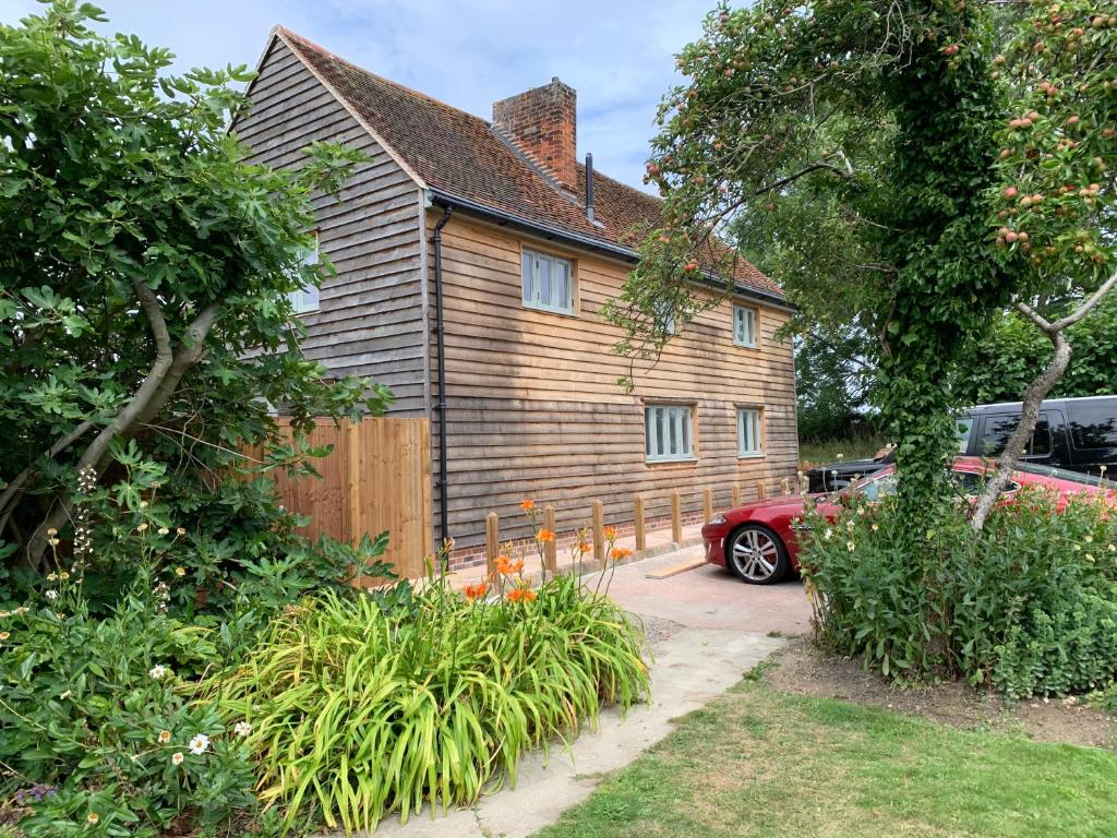 a wooden house with a car parked in front of it at Lodge Cottage in Harwich
