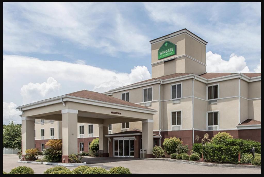 a hotel with a sign on top of it at Wingate by Wyndham Kings Bay Naval Base in Kingsland