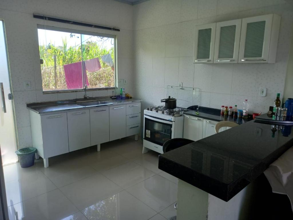 cocina con fregadero, fogones y ventana en casa axé luz no paraíso, en Alto Paraíso de Goiás