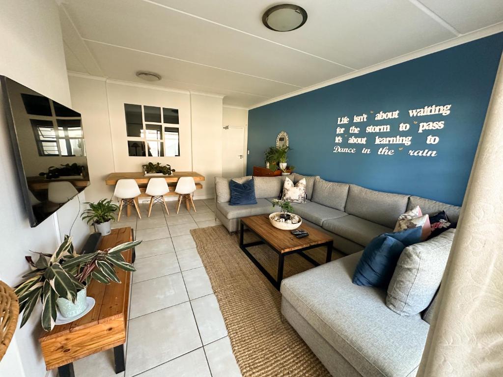 a living room with a couch and a table at Sunny Shores Hideaway in Cape Town