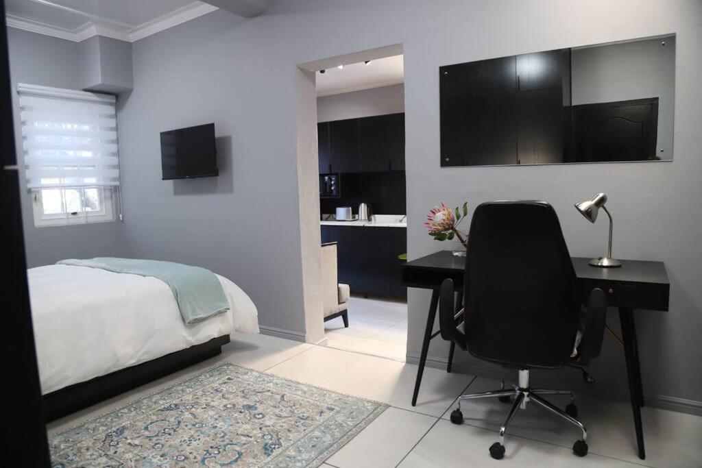 a bedroom with a desk and a bed and a desk and a chair at Trendy Cottage Hideaway in Cape Town