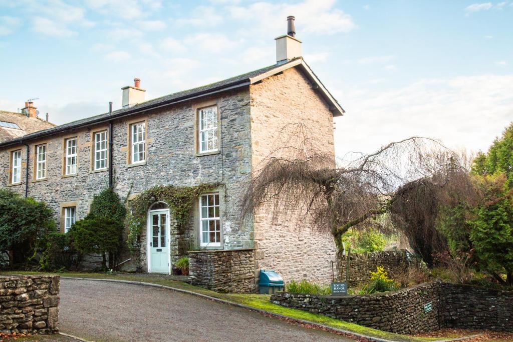 an old stone house with a driveway at Dales View Cottage in Sedbergh