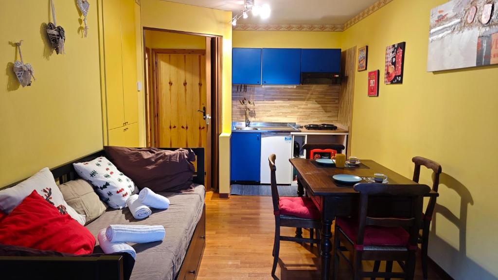 ein Wohnzimmer mit einem Sofa und einem Tisch in der Unterkunft Hostdomus - Casa Borgata in Borgata Sestriere