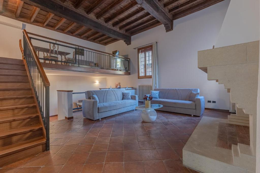 ein Wohnzimmer mit 2 Sofas und einer Treppe in der Unterkunft Exclusive Duplex Apartment in the City Center x9! in Ferrara