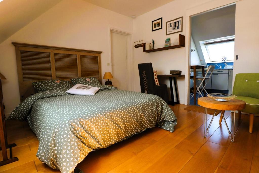 een slaapkamer met een bed en een houten vloer bij La petite hermine in Saint-Malo