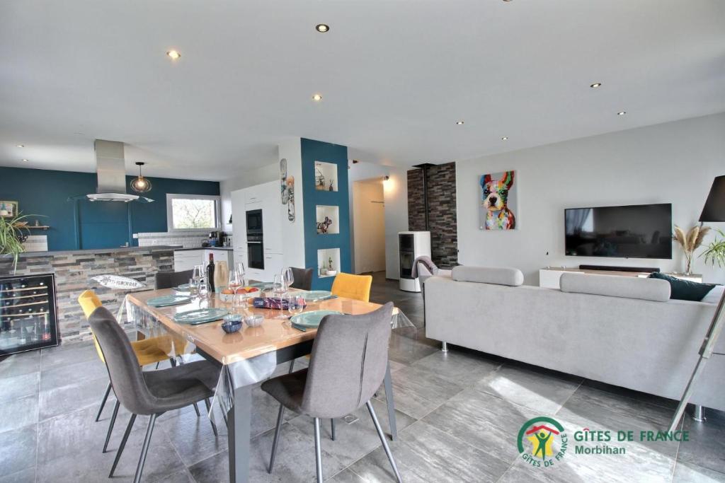 - une salle à manger et un salon avec une table et un canapé dans l'établissement Au petit nid, à Marzan