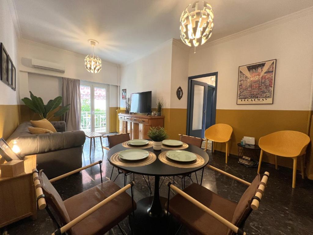 ein Wohnzimmer mit einem Tisch und Stühlen in der Unterkunft Athenian Vintage Style 2 bdr apartment in Athen