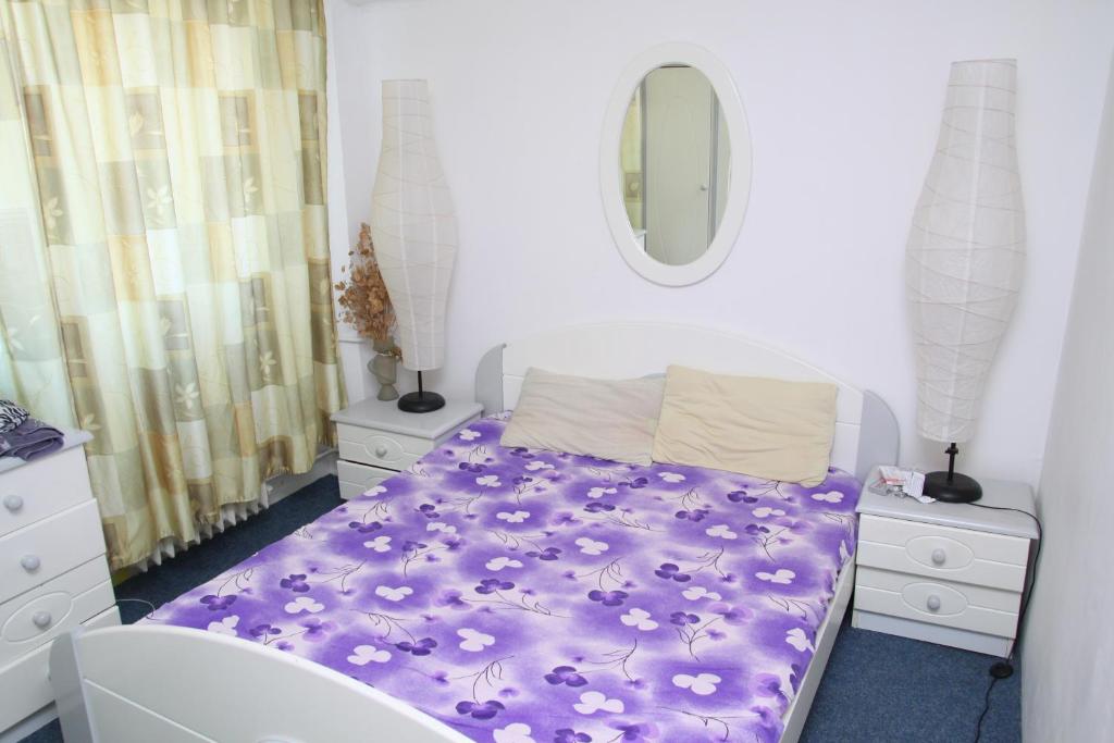 コンスタンツァにあるApartament Gabrielのベッドルーム(紫色のベッド1台、鏡付)