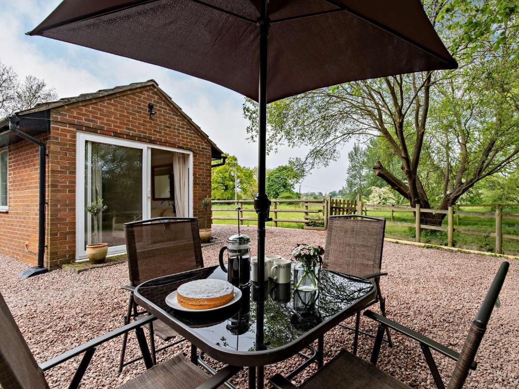 a table with an umbrella on a patio at 2 Bed in Audlem 83192 in Audlem