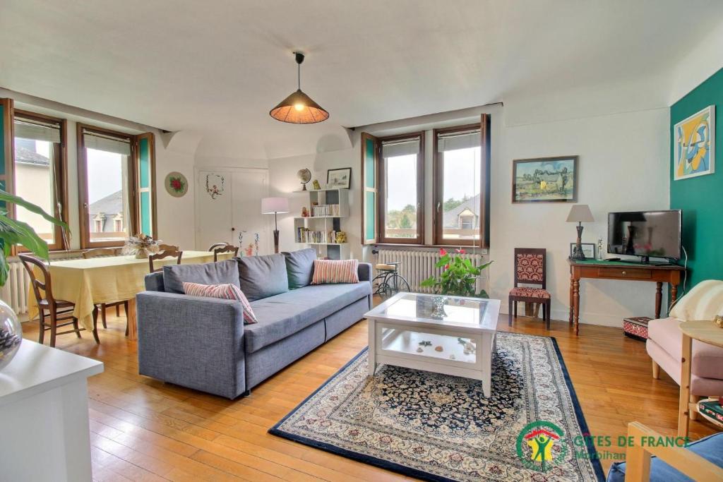 uma sala de estar com um sofá e uma mesa em La maison de marie em La Roche-Bernard