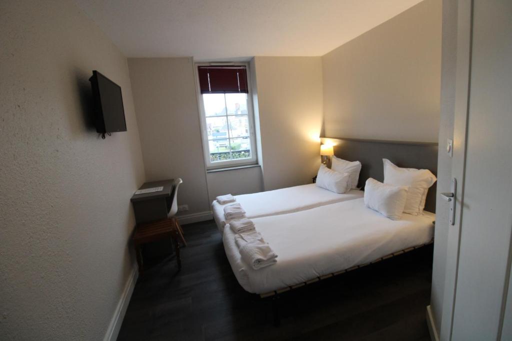 Hôtel Casabianca في مولان: غرفة نوم بسرير وملاءات بيضاء ونافذة