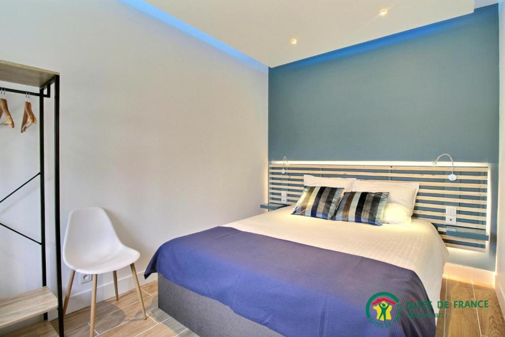 a bedroom with a bed and a blue wall at Ty brestivan in Theix