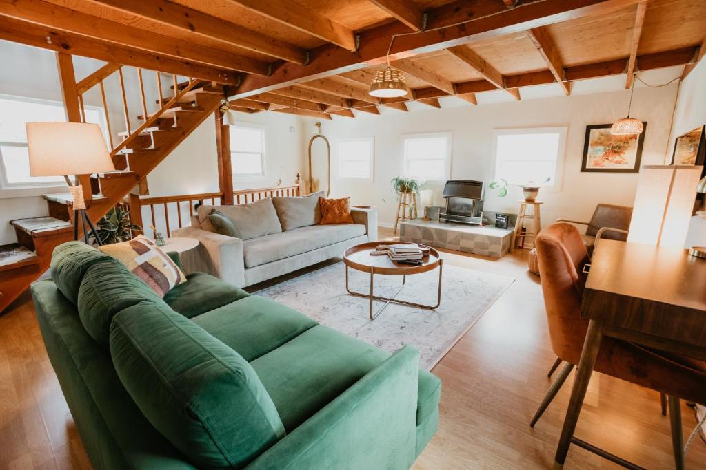 uma sala de estar com um sofá verde e uma mesa em Moonrise on Mill St. Inn- Carriage Haus em Nevada City