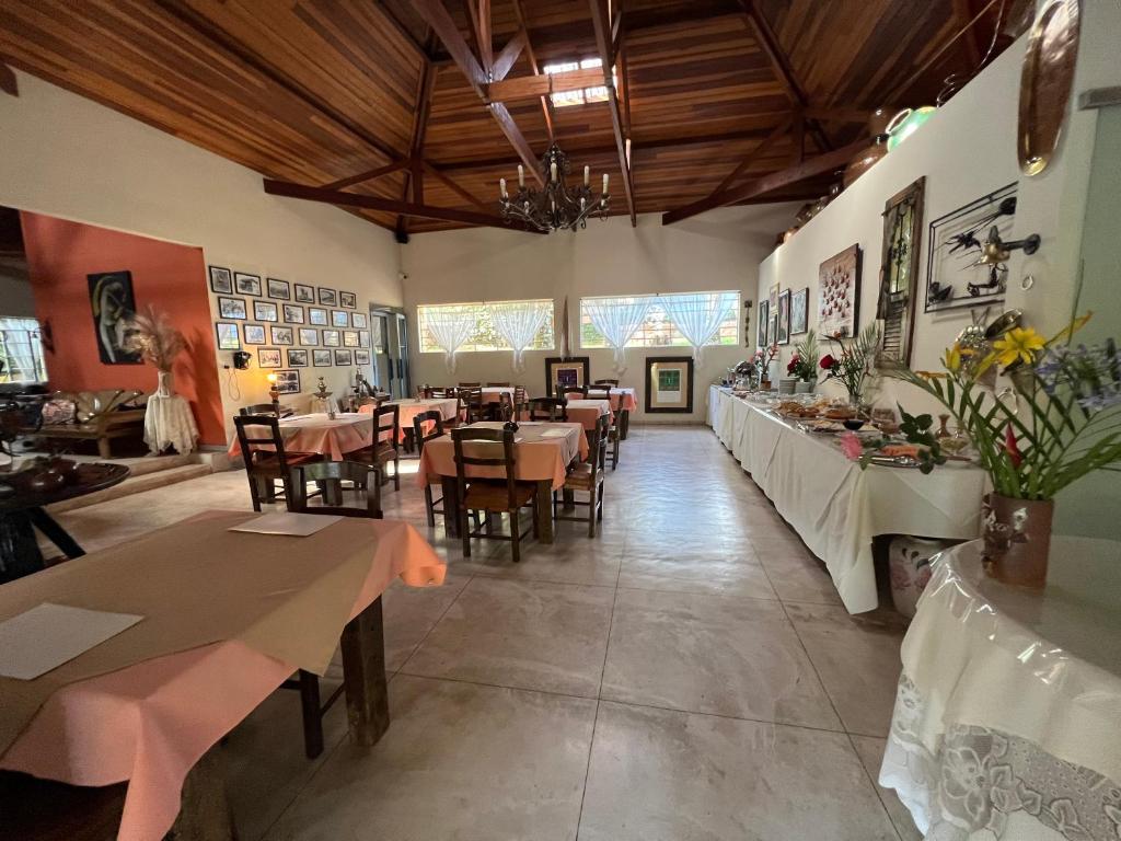um restaurante com mesas e cadeiras num quarto em Pousada Cheiro da Terra em Cunha