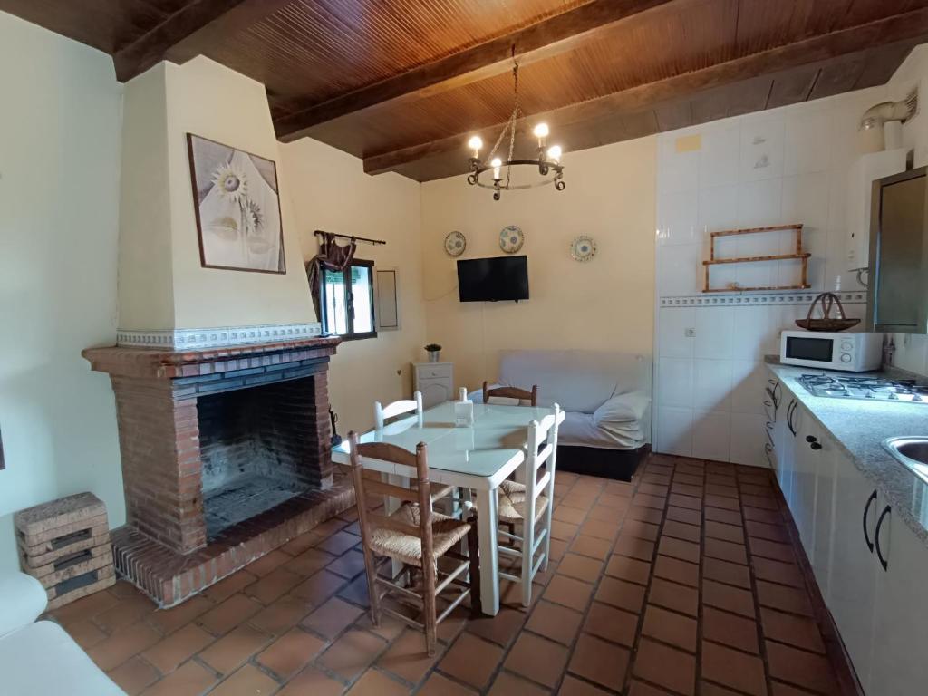 a kitchen and dining room with a table and a fireplace at Las Casitas de Higuera in Higuera de la Sierra