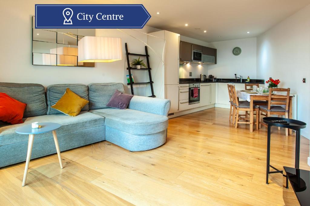 een woonkamer met een blauwe bank en een keuken bij Gorgeous 2BR Apartment with City Views in Leeds