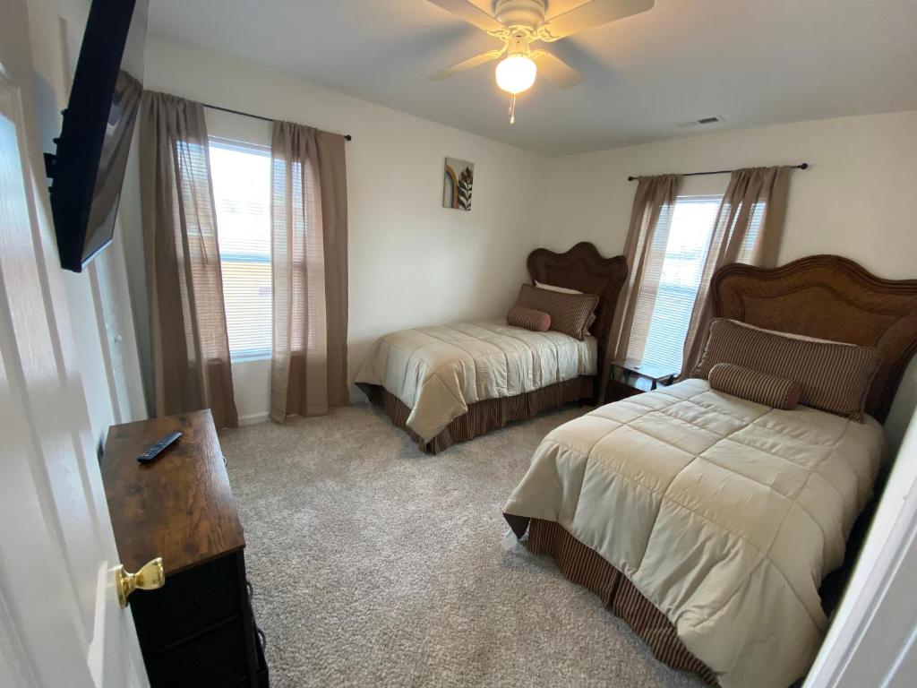 a bedroom with two beds and a ceiling fan at The Chesapeake Gray in Norfolk