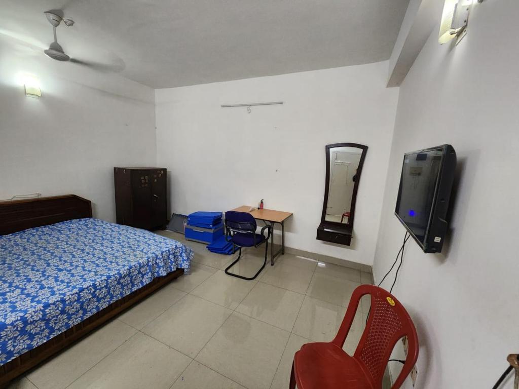 1 dormitorio con 1 cama y TV en la pared en Shaan ppartment, en Guwahati