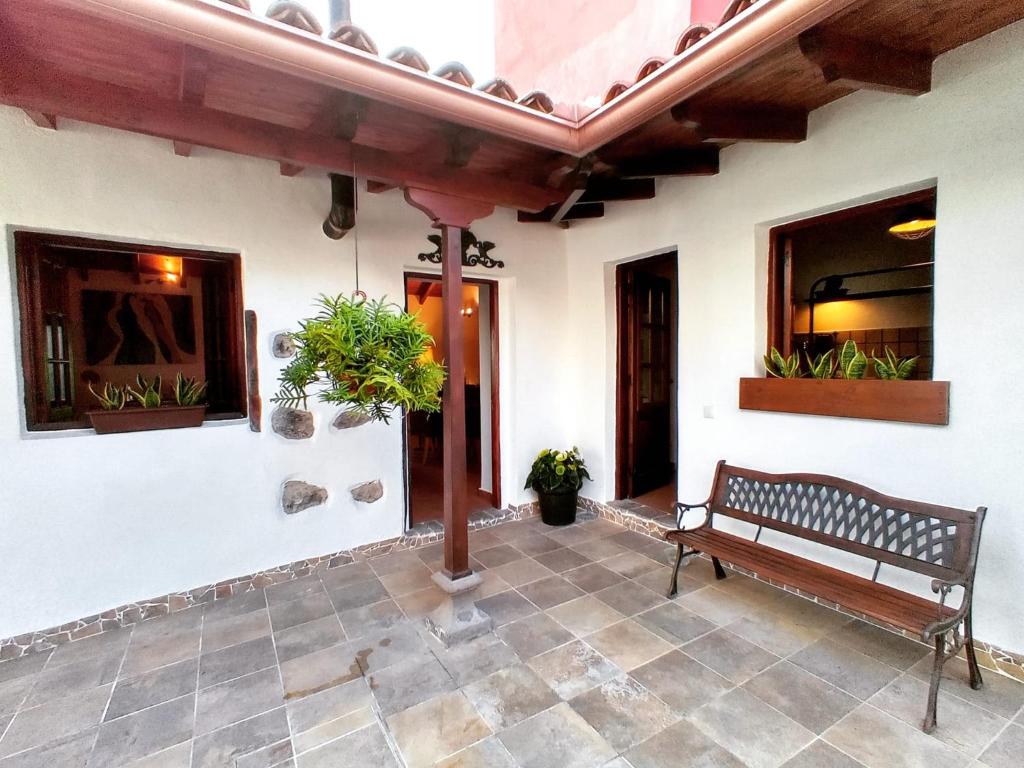un banco sentado en el patio de una casa en Finca La Sirena Vacation Apartments, en Garachico