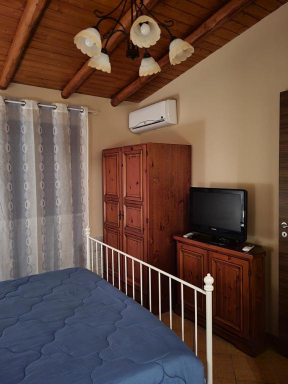 a bedroom with a bed and a flat screen tv at Il Gelsomineto dell'Etna in Nicolosi