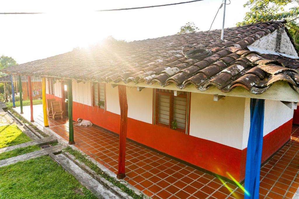 a red and white house with a roof at Casa Finca Genesis in Buga
