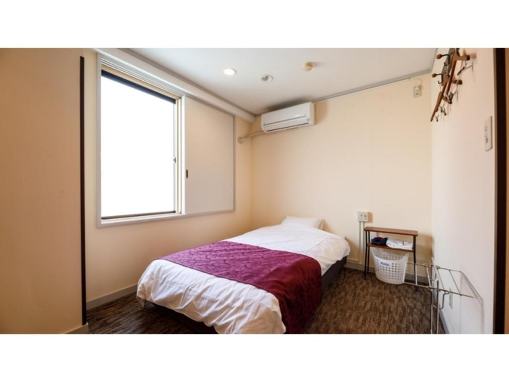 um quarto com uma cama e uma janela em Kanazawa Station Hotel - Vacation STAY 36365v em Kanazawa