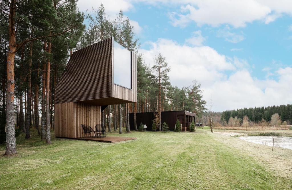 una casa en el bosque con una gran ventana en Jägala Juga Nature Resort SPA, 